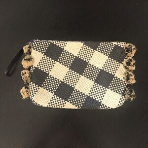 A New Day black & tan woven clutch bag with side pom-poms.